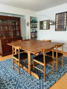 a wooden dining room table and chairs on a blue rug at Between River and Sea Porto Apartment in Porto