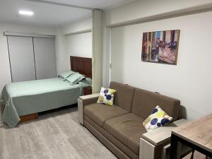 sala de estar con sofá y cama en Moderno mini departamento de estreno, en Lima