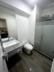 y baño con lavabo, aseo y espejo. en Moderno mini departamento de estreno, en Lima