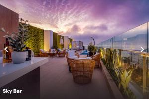 un patio en la azotea con sillas y mesas en un sky bar en Moderno mini departamento de estreno, en Lima