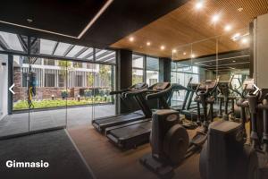 un gimnasio con cintas de correr y elípticas en un edificio en Moderno mini departamento de estreno, en Lima