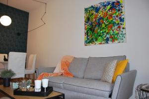 uma sala de estar com um sofá e uma pintura na parede em Suite 51 Appartamento con terrazzo a 50 mt dal lago - Private Parking em Arona