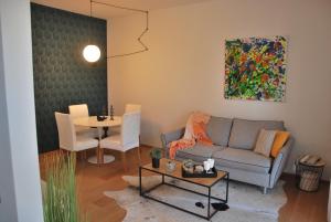 uma sala de estar com um sofá e uma mesa em Suite 51 Appartamento con terrazzo a 50 mt dal lago - Private Parking em Arona