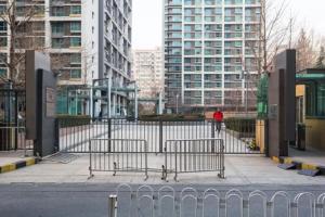 una persona con una giacca rossa che cammina per strada di Beijing Yasmine Seasons Park Apartment Hotel a Pechino