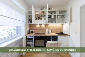 una cucina con armadi bianchi e piano di lavoro di Die Fichtelsuite 1-6 Pers Ferienwohnung nahe Ochsenkopf Süd 800m in Fleckl a Warmensteinach