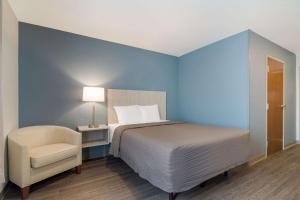 מיטה או מיטות בחדר ב-WoodSpring Suites Morrisville - Raleigh Durham Airport