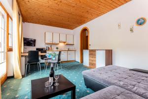 a bedroom with a bed and a kitchen and a table at Appartements Dreimäderlhaus in Maria Alm am Steinernen Meer