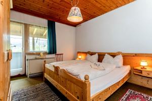 a bedroom with a wooden bed and a desk at Appartements Dreimäderlhaus in Maria Alm am Steinernen Meer