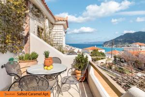 een balkon met een tafel en stoelen en uitzicht op de oceaan bij Fasolaki, Skopelos Town in Skopelos Town