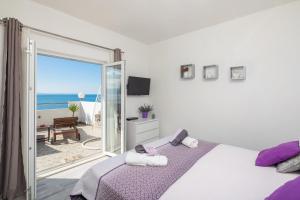 a bedroom with a bed and a view of the ocean at Sky Way Apartments in Dugi Rat