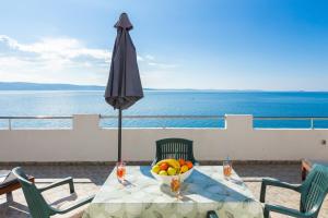 a table with a bowl of fruit and an umbrella at Sky Way Apartments in Dugi Rat