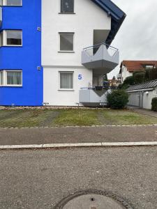 um edifício azul e branco com uma varanda em Mercedes I Stuttgart I Kitchen I Home Office I Parkplatz em Böblingen