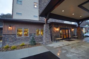 une maison avec une façade en pierre et une terrasse dans l'établissement Stonebrook Lodge, à Cherokee