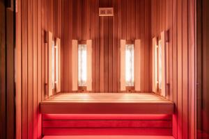 a wooden corridor with two windows and a red bench at Apartmánový Hotel HREBIENOK RESORT in Vysoké Tatry