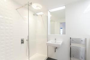 bagno bianco con doccia e lavandino di Destiny Scotland -The Malt House Apartments a Edimburgo