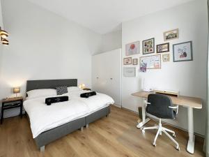 een slaapkamer met een bed en een bureau met een stoel bij Plein Coeur de la Vieille Ville de Sion in Sion