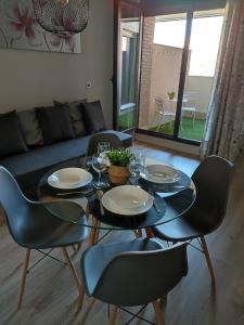 a dining room with a glass table and chairs at Apartamento Servet, parking gratuito in Bormujos