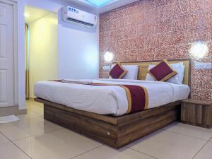 ein großes Bett in einem Zimmer mit Ziegelwand in der Unterkunft Hotel Feathers in Ernakulam