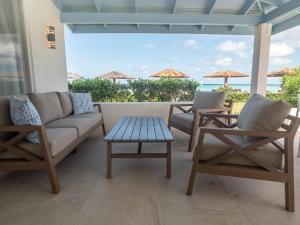 a patio with two chairs and a couch and a table at Antigua Village Beach Resort in Saint Johnʼs