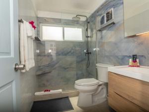 a bathroom with a shower and a toilet and a sink at Antigua Village Beach Resort in Saint Johnʼs