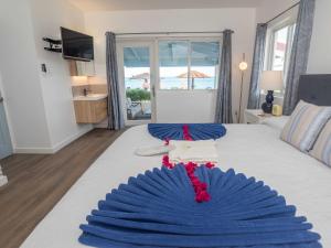 a bedroom with a blue and white bed with a window at Antigua Village Beach Resort in Saint Johnʼs