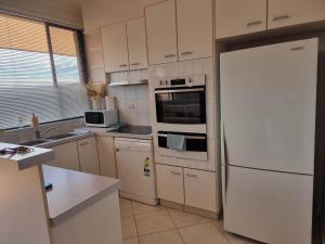 eine Küche mit weißen Geräten und einem weißen Kühlschrank in der Unterkunft Tuggeranong Short Stay #07 - Sleeps 6 in Tuggeranong