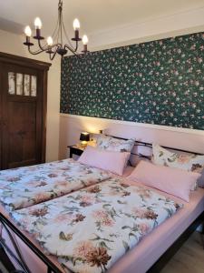 um quarto com uma cama com papel de parede floral em Im alten Rathaus em Bad Liebenstein