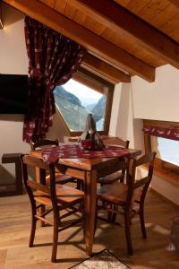 d'une salle à manger avec une table, des chaises et une fenêtre. dans l'établissement Montaz Suite and Sauna, à Valtournenche