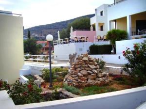 una pila de rocas en un patio al lado de un edificio en Blue Sky Hotel Apartments, en Tolo