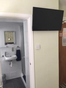 La salle de bains est pourvue d'un lavabo et d'un miroir. dans l'établissement Tregonholme Guesthouse, à Bournemouth