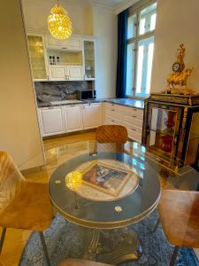 uma sala de estar com uma mesa de vidro e cadeiras em Karlsbad Prestige em Karlovy Vary