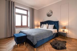 ein Schlafzimmer mit einem blauen Bett und einem Spiegel in der Unterkunft Apartament Kolegialna 8 in Płock