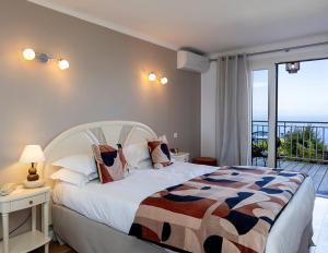 um quarto com uma cama e vista para o oceano em Hôtel Capo Rosso em Piana