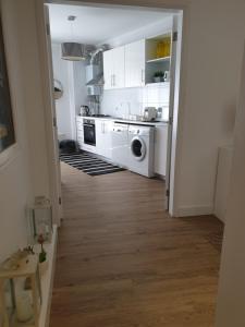 a white kitchen with a washing machine in it at Casa "Vó Minda" - Nazaré - Alojamento Local in Nazaré