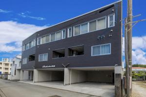 a black building with windows on a street at Southerlies Condominium Onna in Onna