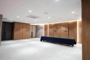 a conference room with a blue table and wooden panels at Ramada Encore by Wyndham CheonAn in Cheonan