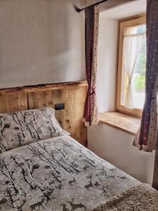 a bedroom with a bed and a window at AL BAIT DA LUCIA Bormio in Bormio