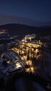 ein großes Gebäude mit Lichtern im Schnee in der Nacht in der Unterkunft Krokus in Wisła