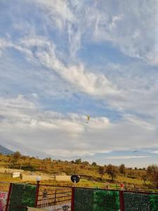 um papagaio a voar no céu sobre um campo em Raahi Stay, Landing site Bir - Stay & Cafe em Bir