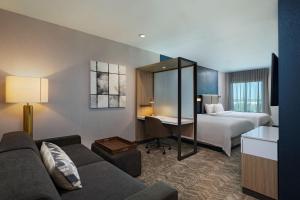 een hotelkamer met een bank, een bed en een bureau bij SpringHill Suites by Marriott Austin North in Austin