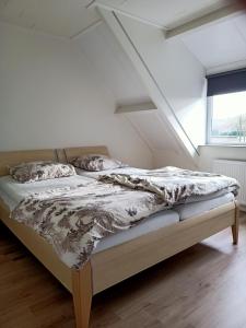 Cama en habitación blanca con ventana en Vakantiehuis Mastdreef, en Breda