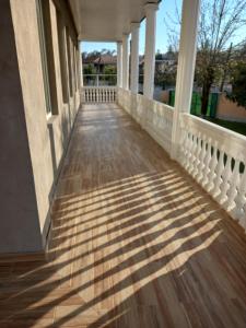 een veranda van een huis met schaduwen op de grond bij Tskaltubo Apartment Mirian Mepe in Tskaltubo