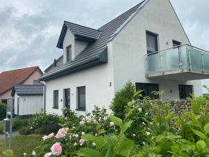 una casa bianca con balcone e alcuni fiori di Villa Major a Göhren-Lebbin