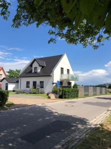 una casa bianca con un tetto nero su una strada di Villa Major a Göhren-Lebbin