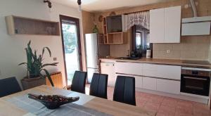 a kitchen with a table and chairs and a kitchen with white cabinets at Apartmaji Ri-100 in Portorož