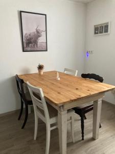 a wooden table with chairs and a cow on the wall at Ferienwohnung Petra in Rust