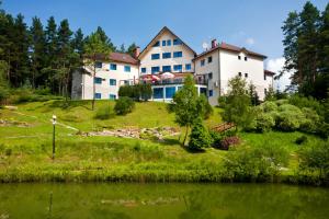 una grande casa su una collina vicino a un lago di Hotel Perła Bieszczadów Geovita a Czarna