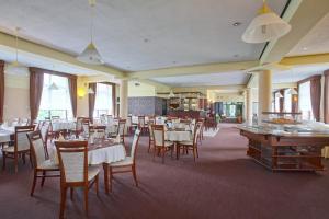 una sala da pranzo con tavoli e sedie in un ristorante di Hotel Perła Bieszczadów Geovita a Czarna