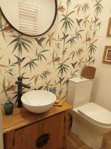 a bathroom with a sink and a toilet and a mirror at Dormir entre limones, Casa de invitados en vivienda familiar in Dos Hermanas