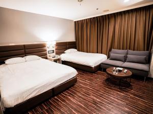 um quarto de hotel com duas camas e um sofá em ORDA HOTEL em Chiba